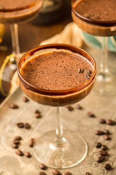 two glasses filled with chocolate drink and coffee beans