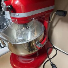 a red stand mixer sitting on top of a counter