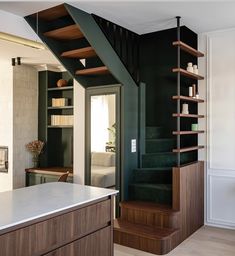 the stairs in this house are made of wood and have bookshelves on them