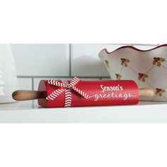 a red rolling pin sitting on top of a counter