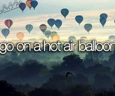 the words go on a hot air balloon are in front of many balloons flying through the sky