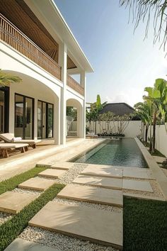 a house with a swimming pool in front of it and grass on the ground next to it