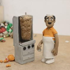 a clay figurine standing next to an oven with bread in it's door