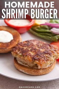 homemade shrimp burger on a plate with lettuce, tomatoes, and mayonnaise