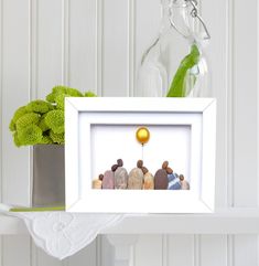 a group of rocks sitting in front of a vase with a yellow ball on it