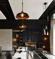 an empty dining room with black walls and chairs