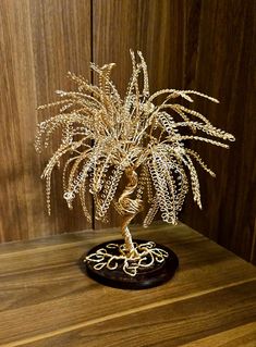 a gold colored plant sitting on top of a wooden table