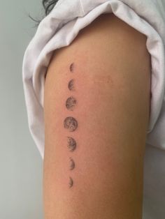 a woman's arm with phases of the moon on it