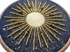 a blue and gold decorative object with lots of tiny objects in it's center