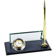 a pen and clock are on a black stand with a glass base that is holding a gold - plated ballpoint pen