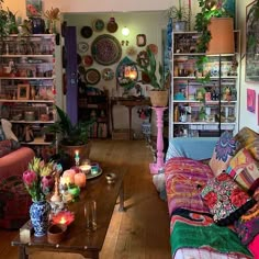 a living room filled with furniture and lots of plants on the wall next to it