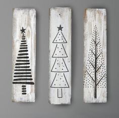 three wooden wall hangings decorated with christmas trees