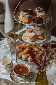 three tiered trays filled with cakes and pastries on top of a table