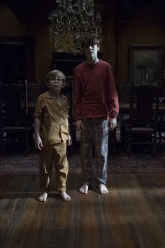 two young boys standing in front of a chandelier on a wooden floor, both wearing pajamas