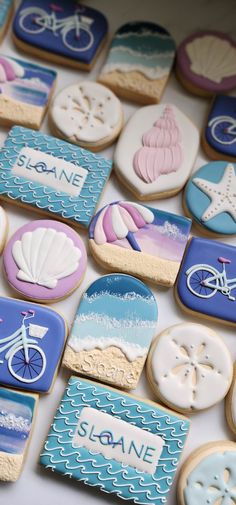 decorated cookies are arranged in the shape of bicycles, seashells and beach scenes