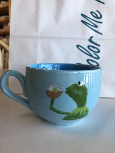 a blue coffee cup sitting on top of a table