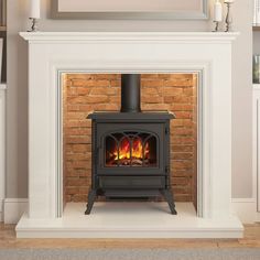 a wood burning stove in a living room next to a brick wall and white fireplace