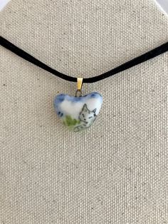 I made these new ceramic charms from white frost porcelain, which is smooth and glassy to the touch after fired with a clear glaze. The gray tabby cat is painted in the foreground with a blue sky & clouds and green grass in the background; the heart is a little smaller than 1 " inch in diameter, and hangs from a brass clasp on a velvet ribbon. The yellow-peach moon sliver is featured with a freshwater pearl; the silver-plated necklace (with tiny silver beads) comes with both of these pendants. The blue bottle is hand-painted in a sun-shape with gold luster highlights. It is a little over 1" tall and 1/2 " wide; it comes with a light pink, iridescent crystal drop and small freshwater pearl that are attached to a dainty, gold-plated necklace. I made these individual charms from porcelain cla Ceramic Charms, Gray Tabby, Pearl Necklace Gold, Blue Sky Clouds, Clay Things, Heart Cat, Ceramic Heart, Iridescent Crystal, New Ceramics