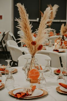 the table is set with orange napkins and place settings