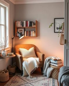 a living room with a chair, bookshelf and rug on the floor in front of a window