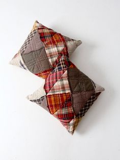 two patchwork pillows sitting on top of each other