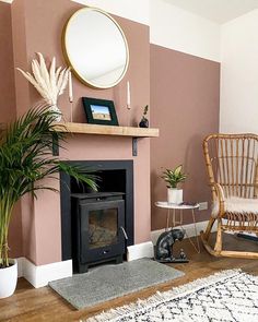 a living room with a fire place, chair and potted plant on the floor