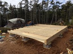 a wooden platform with a tent in the background