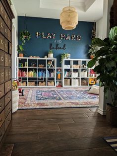 a living room filled with lots of furniture and bookshelves next to a plant