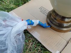 a blue and white toothbrush sitting on top of a cardboard box next to a lamp