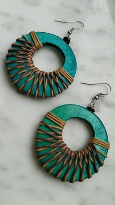 two pairs of earrings on top of a marble counter with white and blue beads in the middle