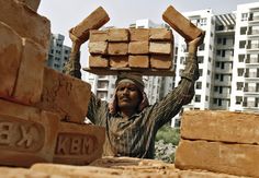 a man carrying bricks on his head