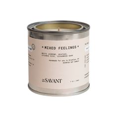 a candle that is sitting inside of a metal can on a white background with the words mixed feelings written in it