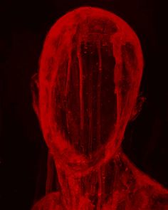 a man is shown in red light with ice on his face and body, while the image appears to be distorted