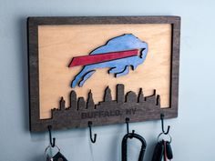 Show your team pride with this awesome handmade Buffalo Bills key hanger! Made from Maple wood! Measures 10 3/4" x 7.5" and just about 3/8" thick. Light weight on the walls, sturdy enough for plenty of keys, dog leash, or even a light jacket! These are all made to order, which means the wood grains may be different, but also allows for customization! **Hooks come unattached for safer shipping** We are always willing to create other sports teams! If you don't see a design you're looking for, shoo Buffalo Bills Svg, Buffalo Bills Logo, Football Wall Art, Buffalo Bill, Hook Hanger, Key Hanger, Key Hook, Bookshelf Decor, Farmhouse Christmas Decor