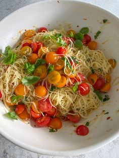 a white bowl filled with pasta and tomatoes