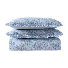 three pillows stacked on top of each other in front of a white background with blue flowers