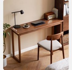 a wooden desk with a laptop and lamp on it