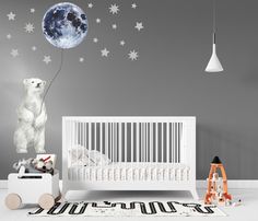 a baby's room with stars and moon decals on the wall, including a white crib