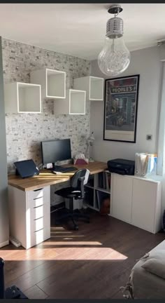 a room with a desk, computer monitor and laptop on it