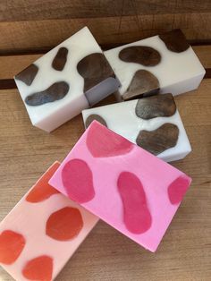 three soap bars with hearts on them sitting on a wooden table next to each other