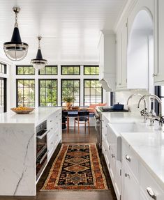 a kitchen with an area rug on the floor next to the sink and countertop