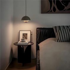 a bedroom with a bed, lamp and pictures on the wall