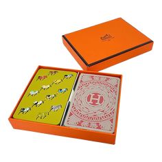 two playing cards in an orange box with horses on them