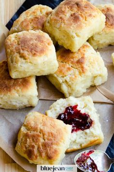 biscuits with jam and butter are on a paper towel next to a bowl of jelly