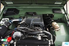 the engine compartment of a green truck with its hood open