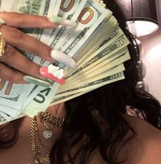 a woman holding cash in her hands and wearing gold jewelry on top of her head