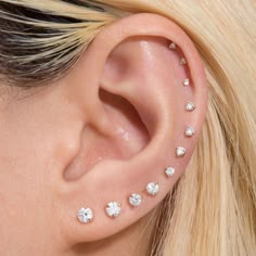 a close up of a person with ear piercings on their ears and behind the ear