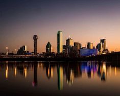 a city skyline is reflected in the water