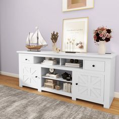 a living room with purple walls and a white entertainment center on top of a rug