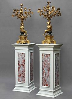 two white and gold vases sitting on top of each other